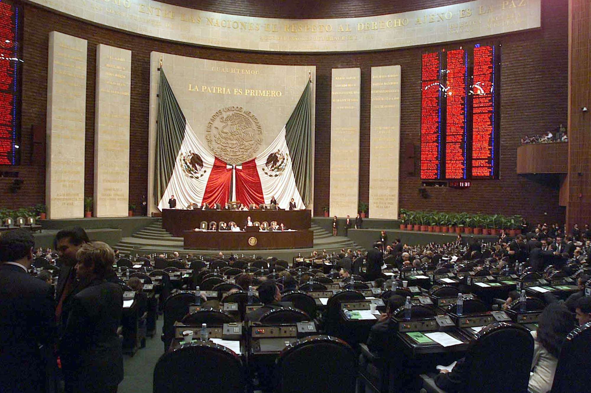 Vista del salón de sesiones de la Cámara de Diputados de México, con la tribuna y la bandera nacional